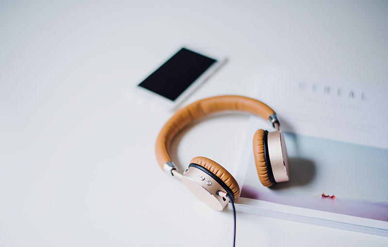 Headphones resting on a desk near a smartphone