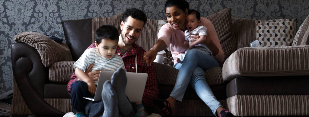 Happy family viewing laptop together
