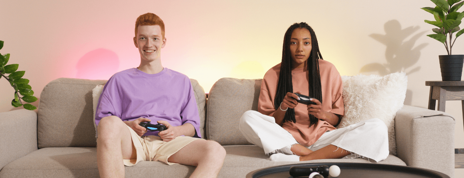 A man and a woman sitting on a couch with video game controllers