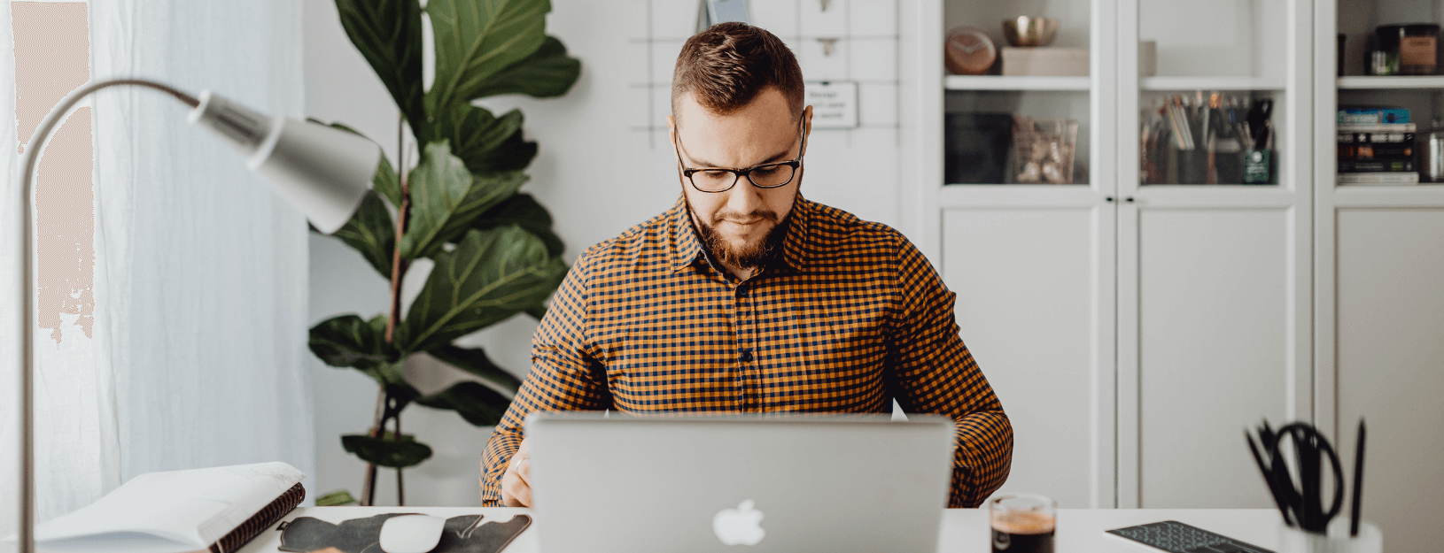 Businessman asleep at laptop, representing a slow internet connection caused by lack of low latency.