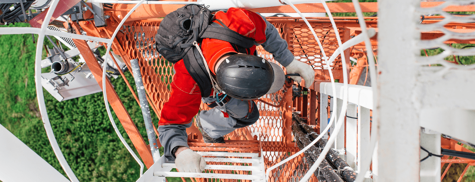 Network technician climbing a wireless tower