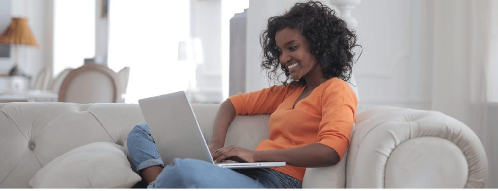 Picture of a woman sitting on a couch and using a laptop