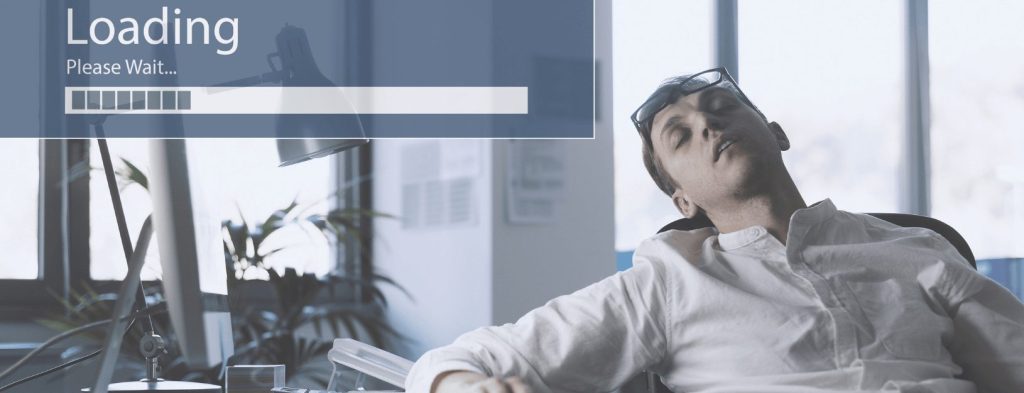 Stock image of man asleep at desk while waiting on slow internet