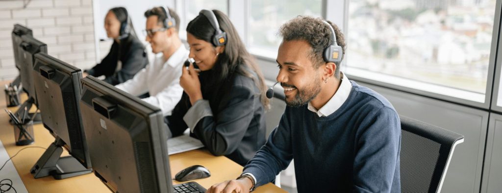 Four support agents with headsets are working at their computers