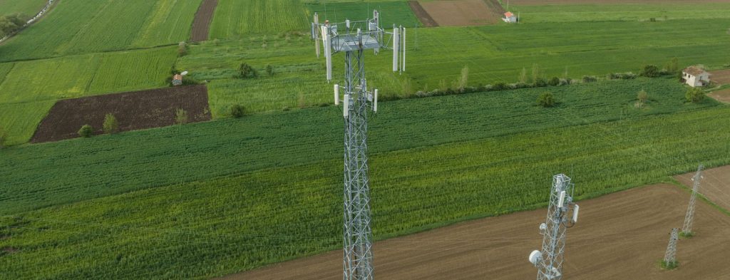 Drone shot shows wireless tower with APs towering over a rural landscape.