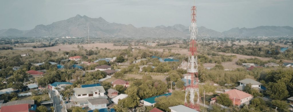 A wireless tower stands amid a rural setting